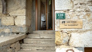 Una escalera de piedra que conduce a una puerta de madera, un cartel que indica la habitación número 106 y una placa de madera con texto.