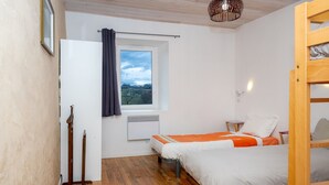 Una habitación con dos camas, ventana con vistas, calefacción suelo de madera.