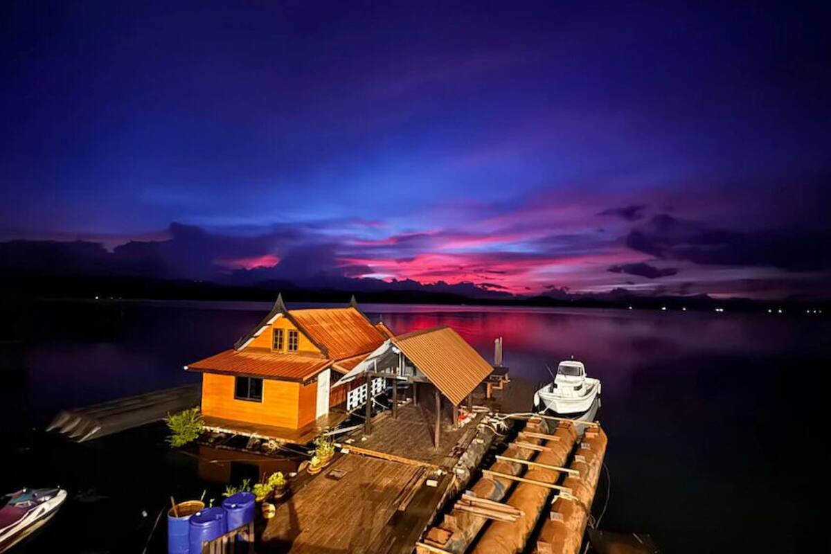 A wooden dock with a house and a boat.