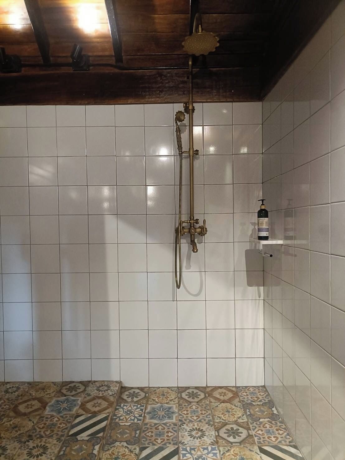 Ducha con cabezal de ducha de mano y grifo empotrado.
