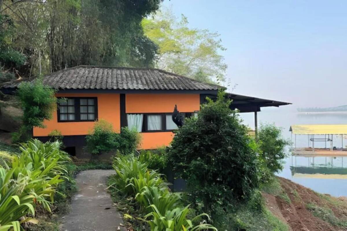 A house with a tiled roof, a small porch, and a pathway leading to it.