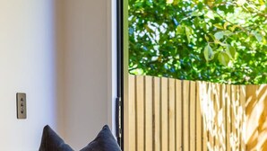 A modern living room with a leather sofa, a dark throw pillow, and a beige throw blanket. - Walk to Canterbury Uni has own private car park (Christchurch)