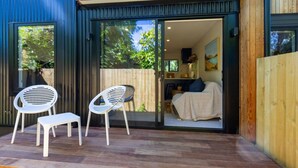 A modern house with a patio area featuring two white plastic chairs and a bench. - Walk to Canterbury Uni has own private car park (Christchurch)