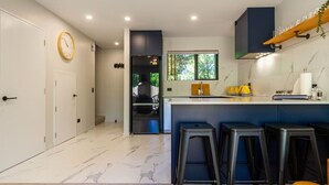 A modern kitchen with a marble floor, a yellow clock, and a bar area with stools. - Walk to Canterbury Uni has own private car park (Christchurch)