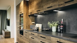 Une cuisine moderne avec des meubles en bois, un plan de travail foncé et un four encastré.