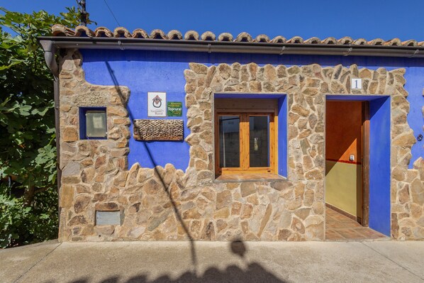 A stone building with a blue exterior, a wooden door, and a small window. - Country House 'El Alarife' with Mountain Views, Wi-Fi, and Air Conditioning (Sediles)