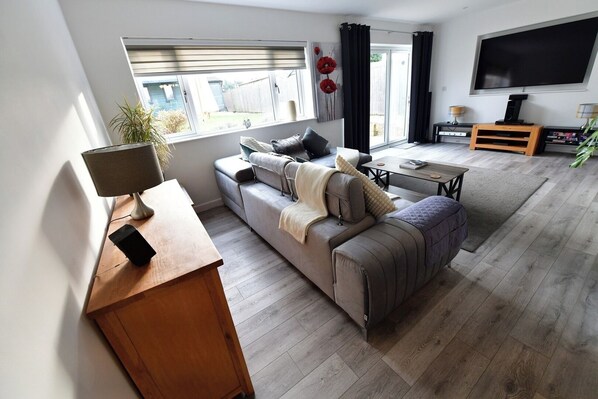 Relax in this inviting living room with a sofa, armchair, and flat-screen TV.