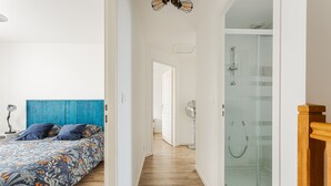Une chambre à coucher avec un lit, une tête de lit bleue et un plancher en bois.