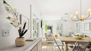 A modern dining area with a wooden table, chairs, and a chandelier.