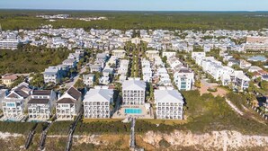 A coastal residential area with modern houses, a beach, and a clear view of the ocean.