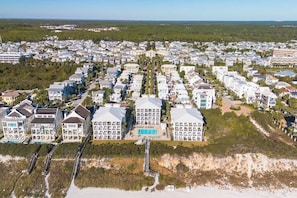 A coastal residential area with modern houses, a beach, and a clear view of the ocean.