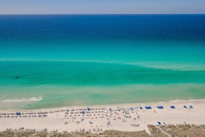 A beach with clear turquoise waters and a sandy shore.