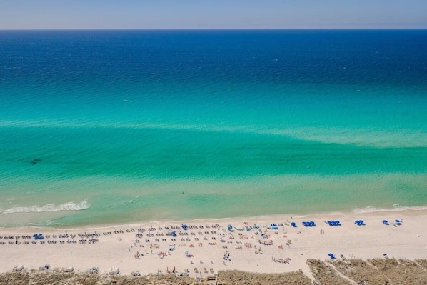 A beach with clear turquoise waters and a sandy shore.