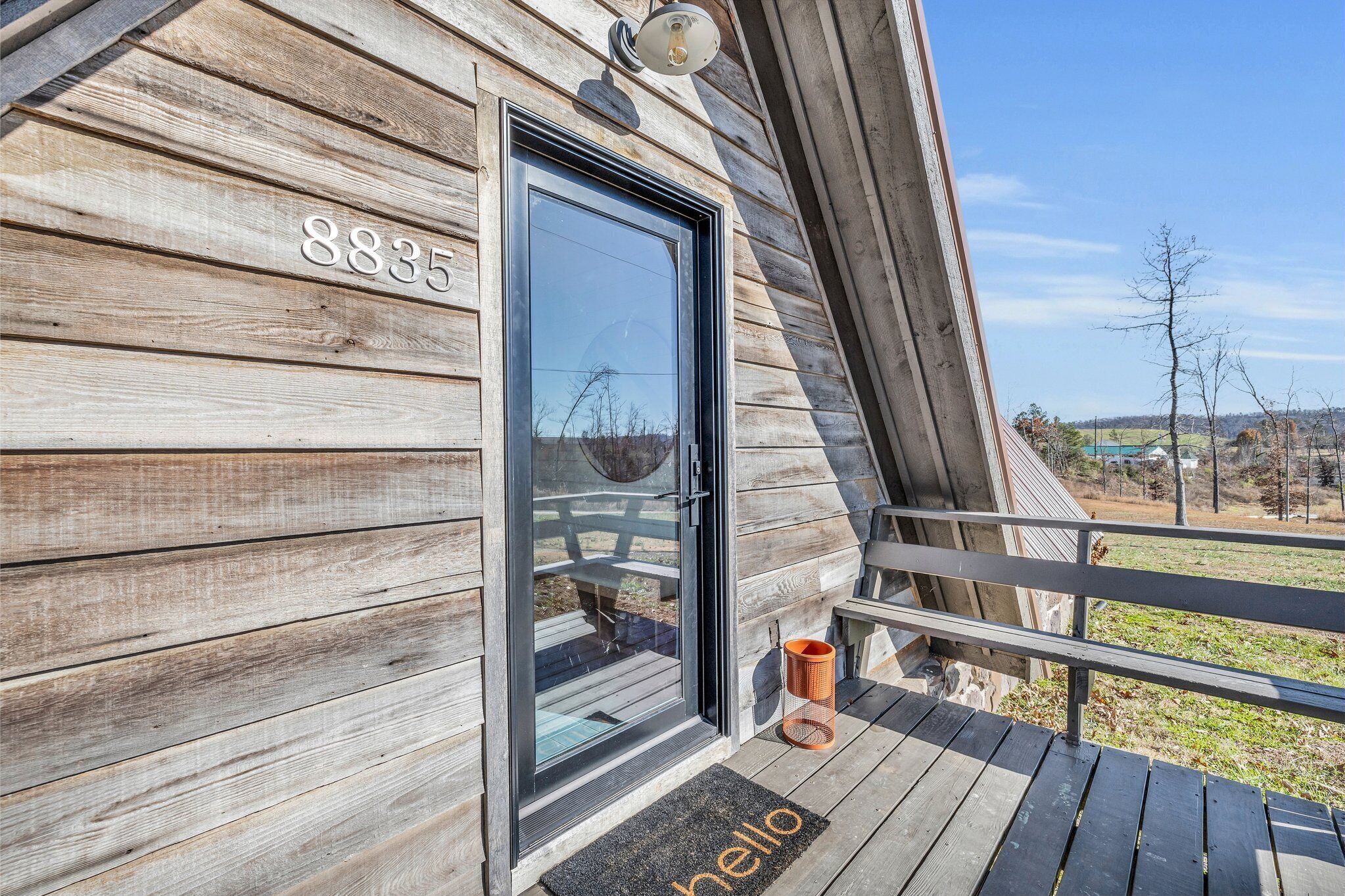 A wooden exterior with a black door and a number "8835" above it.