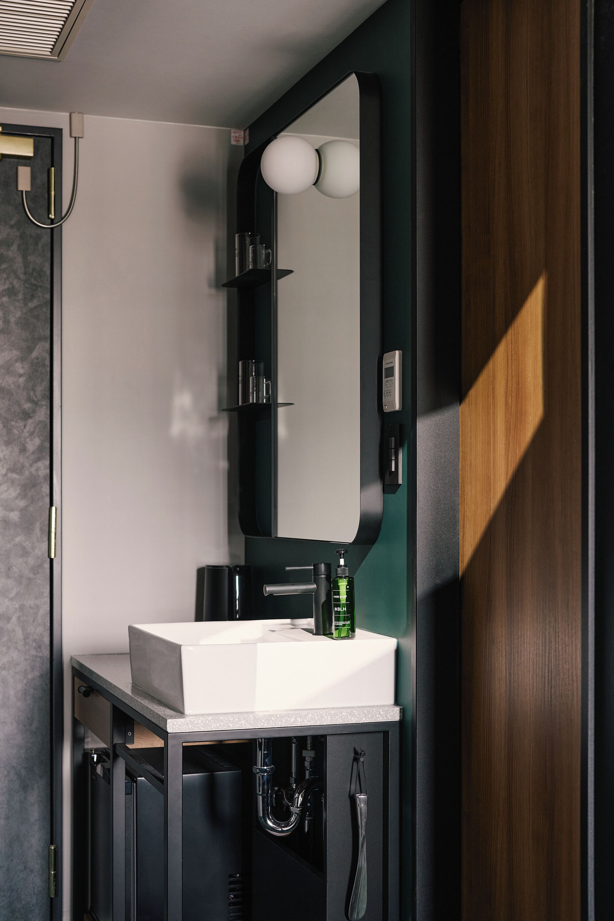A modern bathroom with a white sink, a mirror, and a shower.