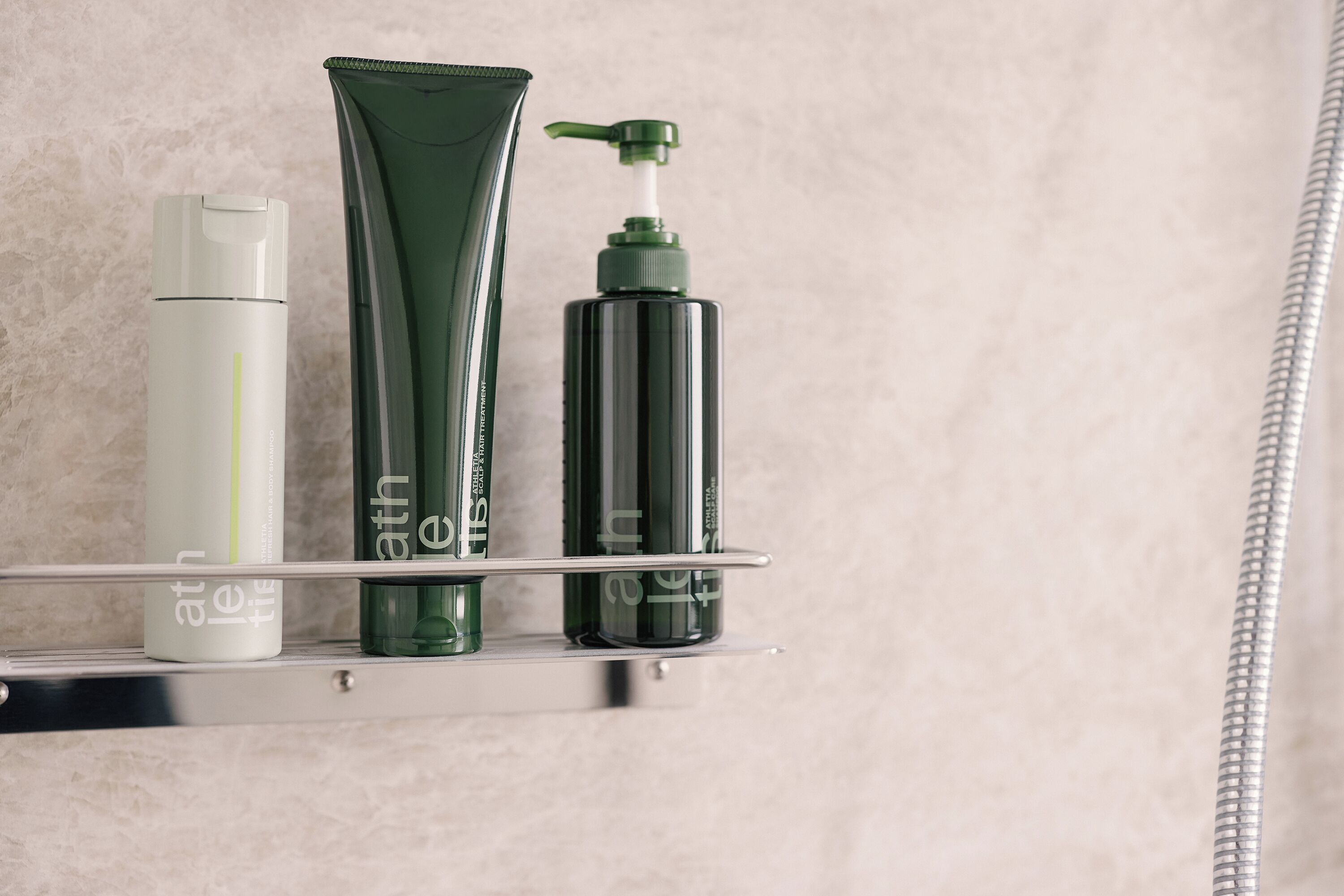 A bathroom shelf with three toiletry bottles.