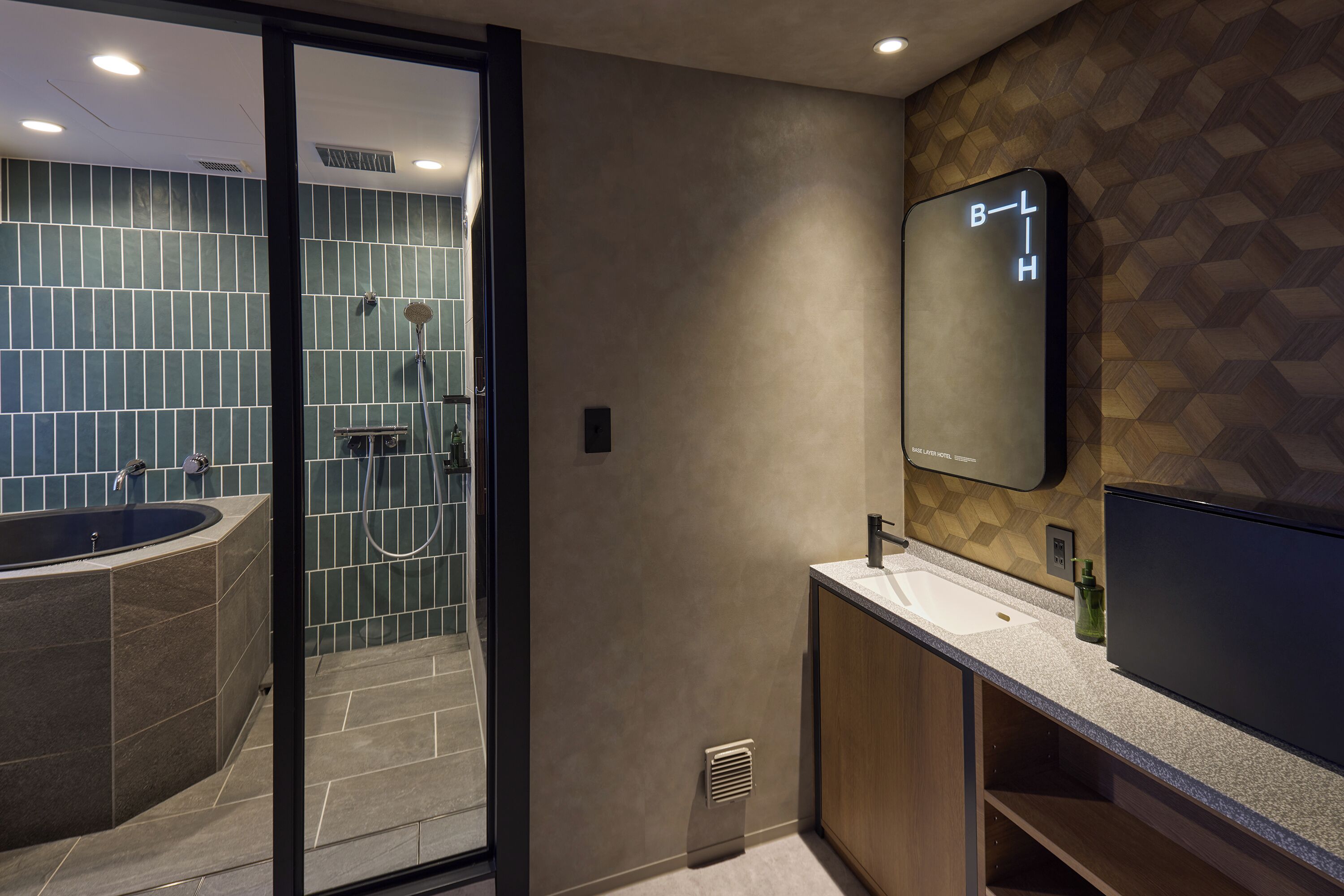 A modern bathroom with a bathtub, shower, and a large mirror.