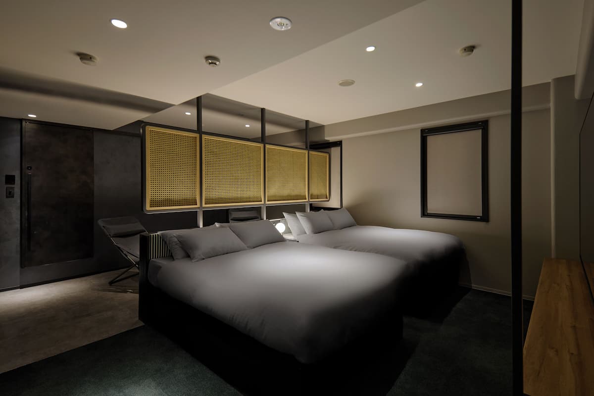 Een moderne slaapkamer met een groot bed, een bureau en een stoel.