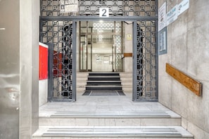 Enter building 2 through the geometric-patterned metal gate.