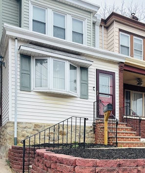 Traditional two-story home with a front entrance, porch, and double-hung windows.