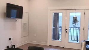 Une cuisine moderne avec un plan de travail noir, un évier en acier inoxydable et des luminaires suspendus.