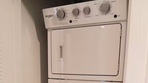 Une machine à laver et un sèche-linge Whirlpool superposés, installés dans une buanderie.