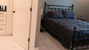 Une chambre à coucher avec un lit, une armoire et une porte.