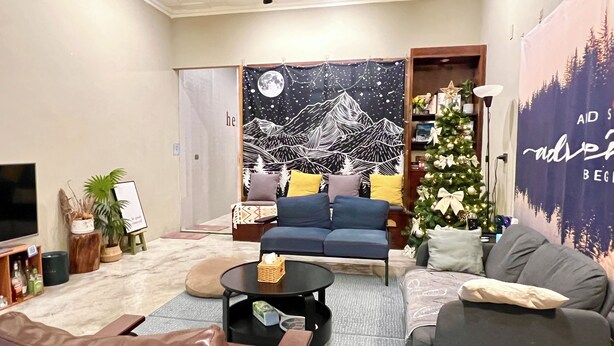 Una sala de estar moderna con un sofá, sillones, una mesa de centro y un árbol de Navidad.