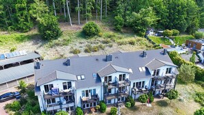 A multi-story residential building with a flat roof, multiple balconies, and a driveway. - Residence Waldidyll FeWo Kleiner Stubber - with use of the swimming pool at AHOI Sellin - (Sellin)