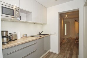 A modern kitchen with a microwave, toaster, and coffee maker. - Walidyll Residence, "Kleiner Stubber" Vacation Rental - with pool access at AHOI Sellin - (Sellin)