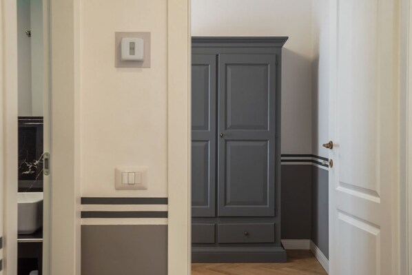 A hallway with a wardrobe, a light switch, and a door.