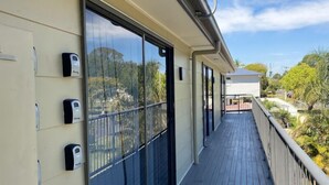 A balcony with a view of a residential area, a white building, and a clear sky. - Smart Suites Self Check-in Apartments - 73 Bale (Rocklea)