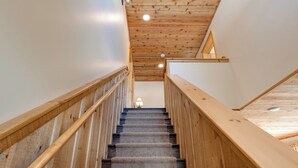 Eine Holztreppe mit Teppichstufen und einem Holgeländer.