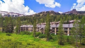 Ein Hotel mit mehreren Gebäuden, umgeben von dichtem Wald und Bergen im Hintergrund.