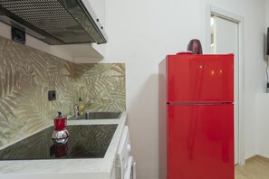 A kitchen with a red refrigerator, a sink, and a stove. - Check in information:You won’t need to meet anyone to access the apartment. Before arrival, you will receive a link to access the Guest Portal, where you can complete the self check-in directly from your phone by entering the ID details of all guests a (Milan)