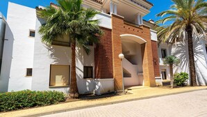 A modern building with a white facade, a brick section, and a central archway. - Modern, ground floor Casares Playa (Casares)