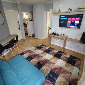 A compact living space with a bed, a desk, and a TV mounted on the wall. - APART FANTÁSTICO - HAKKA EVENTOS E METRÔ (São Paulo)