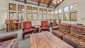 A spacious room with large windows, wooden furniture, and a high ceiling. - The Meadows- Charmed Ski & Relax Studio (Kirkwood)
