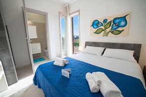 Une chambre dâhĂŽtel avec un lit, un tableau, une salle de bain et une vue.