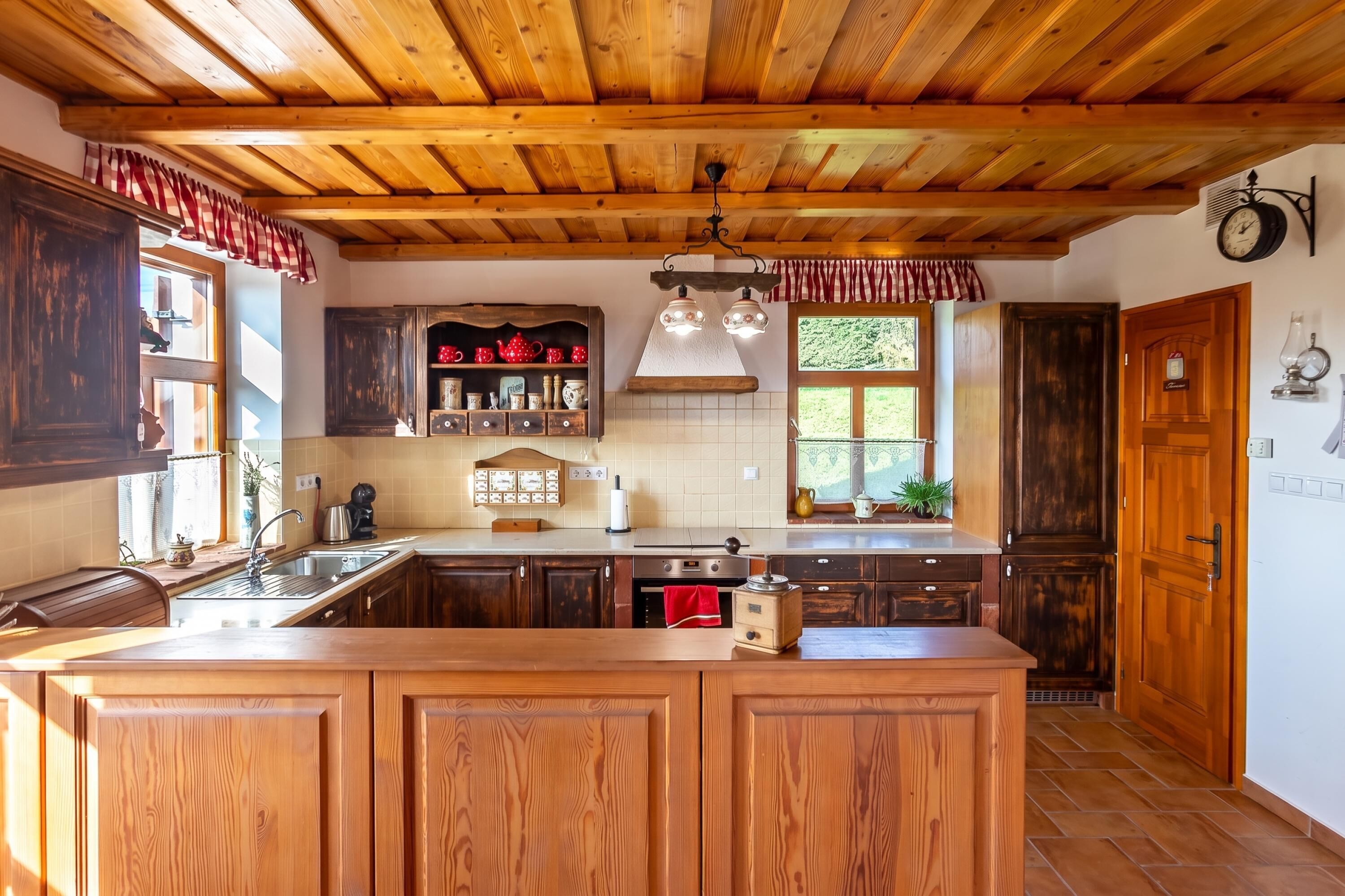 A kitchen with wooden cabinets, a central island, and a window with a view of greenery.