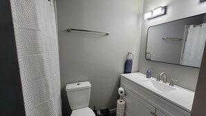 Ein modernes Badezimmer mit Toilette, Waschbecken und Spiegel.