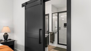 Una habitación de hotel moderna con una puerta corrediza que da a la zona de la ducha.