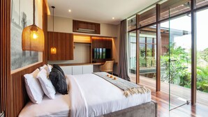 Ein modernes Schlafzimmer mit einem großen Bett, einem Fernseher und Blick auf Grün.