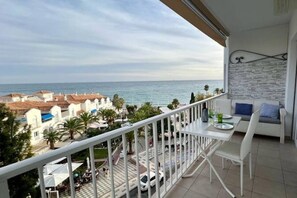 A balcony with a view of the sea and buildings. There is a table and a chair on the balcony. - Apartment with Incredible Sea Views and Balcony (Nerja)