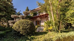 A house surrounded by lush greenery and a well-maintained garden. - Luxury Villa! Pool, Garden, and Jacuzzi. Granada (Albolote)
