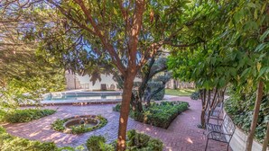 A courtyard with a circular water feature, paved walkways, and benches. - Luxury Villa! Pool, Garden, and Jacuzzi. Granada (Albolote)