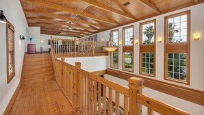A wooden staircase with a railing leading to a second-floor balcony. - Large Family Home, Pool, Pet Friendly and Steps from the Beach (Jekyll Island)