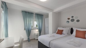 Habitación de hotel con dos camas, un escritorio y una silla.