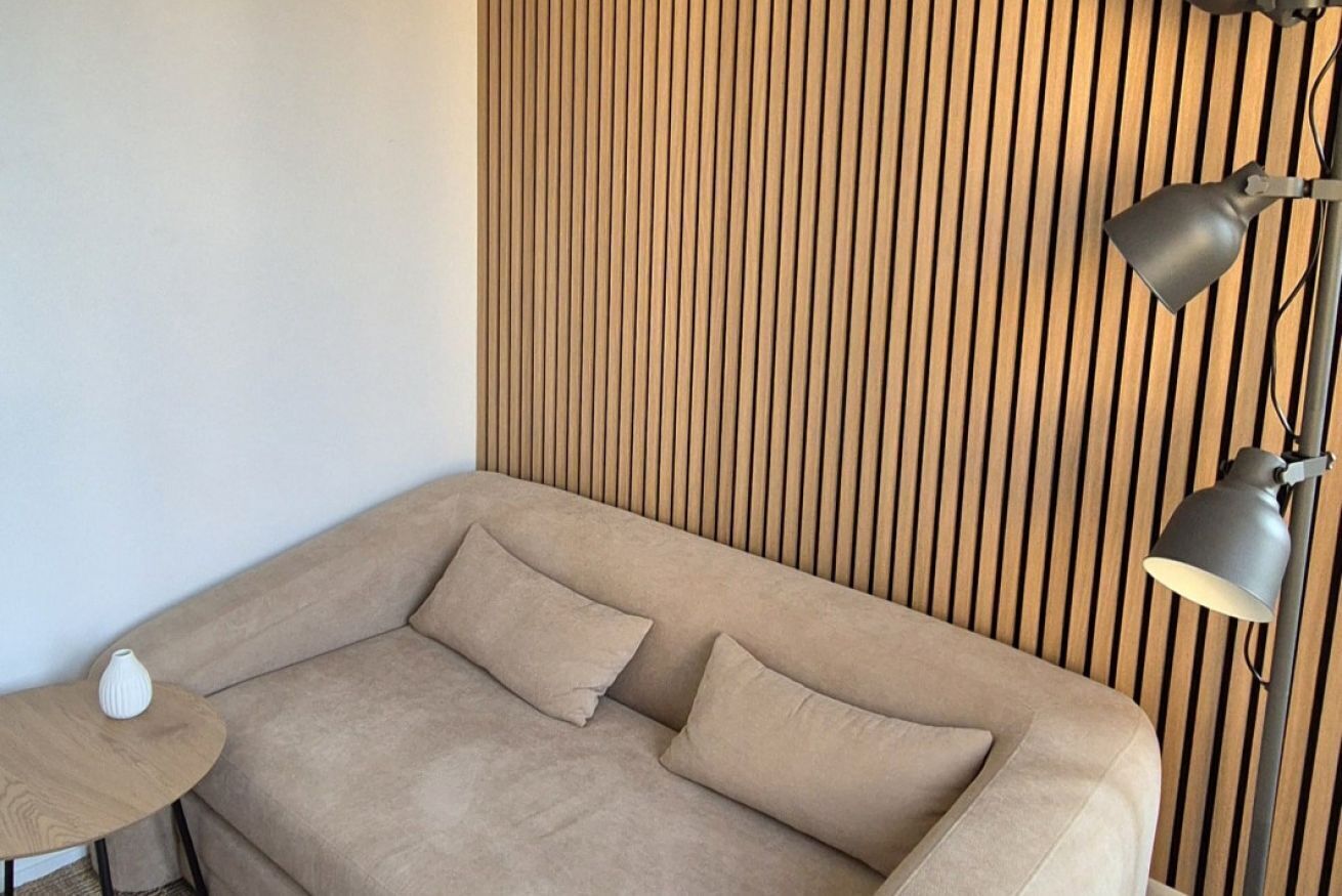 Une pièce moderne avec un canapé, une petite table ronde et une lampe.