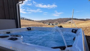 Ein Whirlpool mit Wasserstrahlen vor ländlicher Kulisse.
